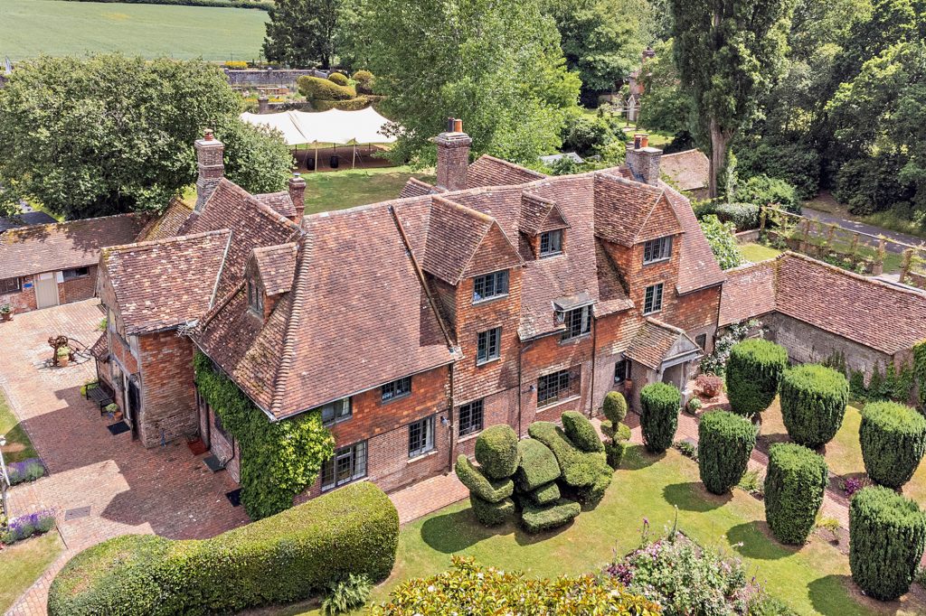 A birds-eye view of Pekes Manor House, showing the frnt entrance, topiary and lawns.